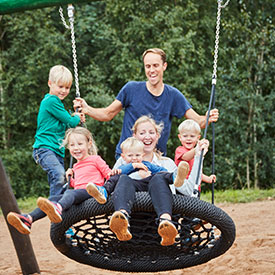 Children and parents swinging on a group basket swing 